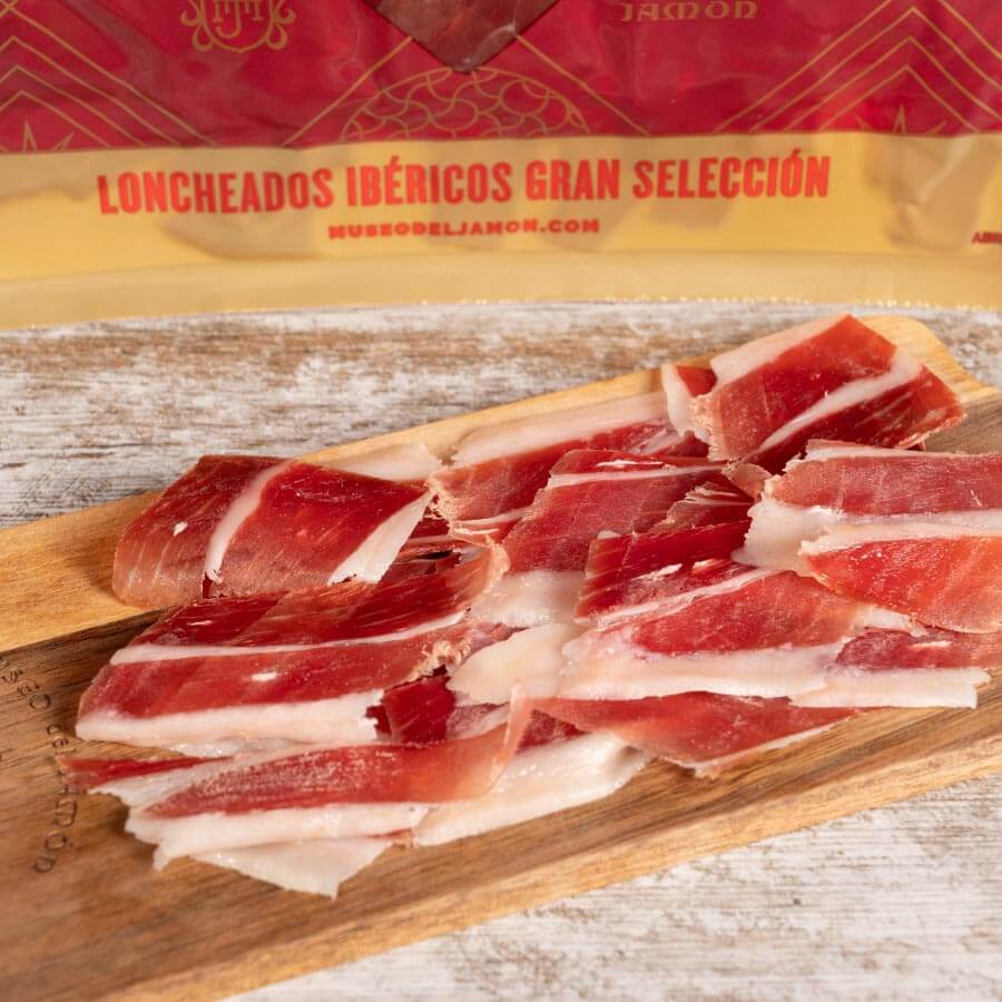 Lonchas de Jamón Ibérico Gran Selección sobre tabla de madera.