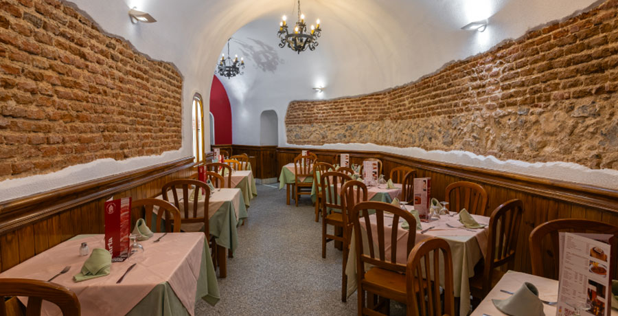 Interior de un restaurante del Museo del Jamón en Madrid, con paredes de ladrillo visto y mesas listas para los comensales