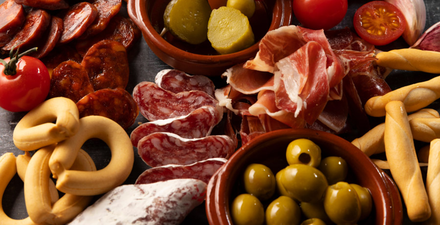 Tabla de embutidos ibéricos con jamón, chorizo, salchichón, pan y aceitunas