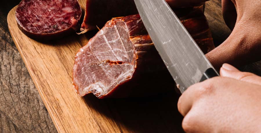 Corte de lomo ibérico de bellota sobre tabla de madera, preparado para servir en el Museo del Jamón