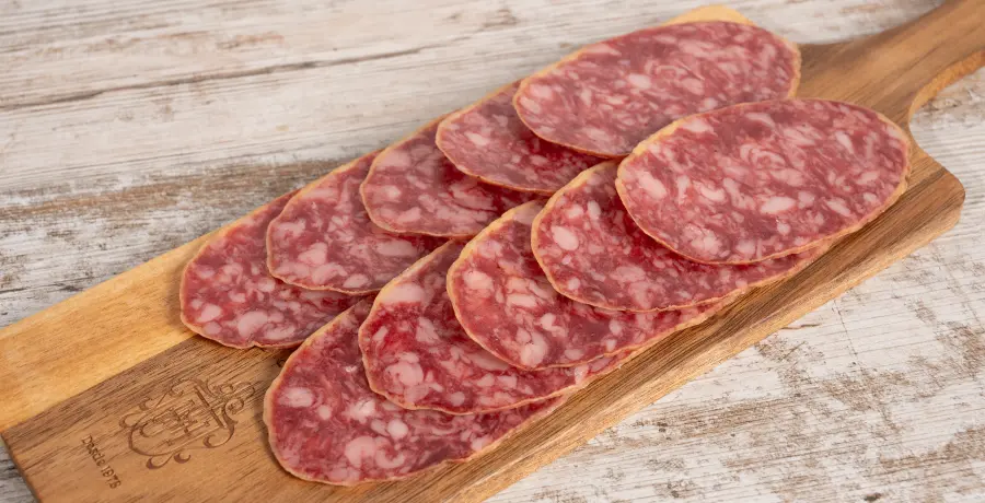 Salchichón ibérico de bellota loncheado sobre tabla de madera